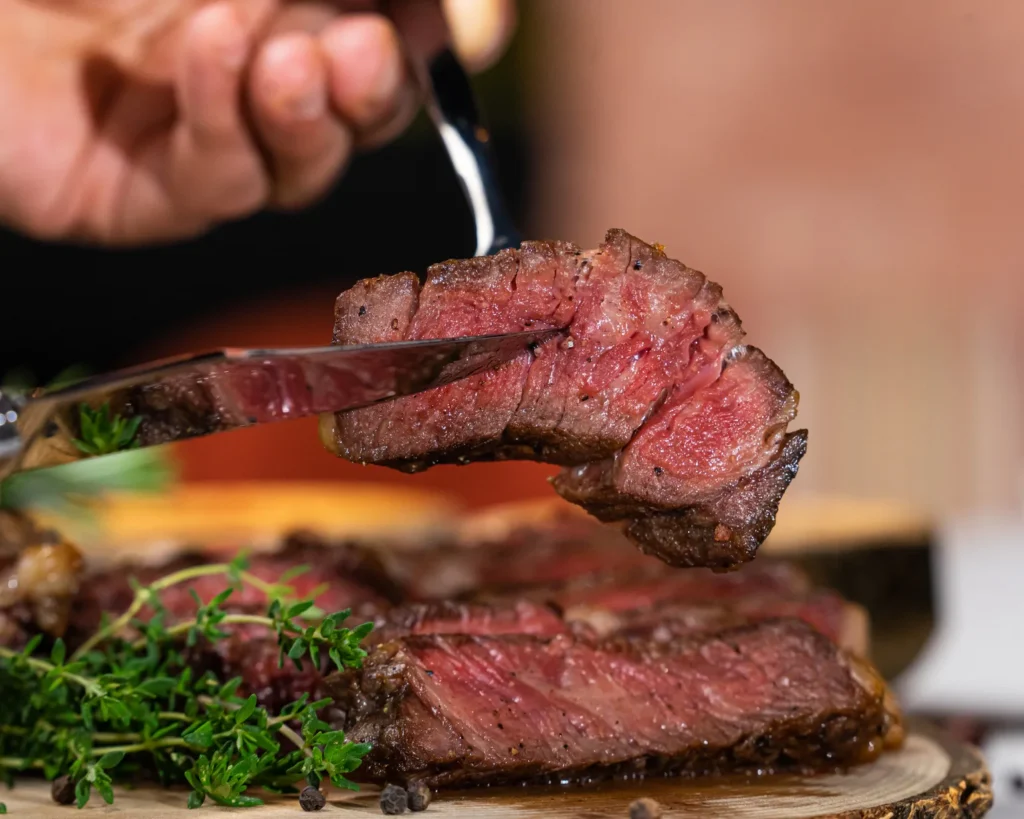 Aufgeschnittenes Steak, medium rare, auf einem Holzbrett
